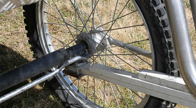 Detalle de la ballesta de Kevlar anclada al eje trasero, junto a la rueda de trial del Coche de Caballos Navarro